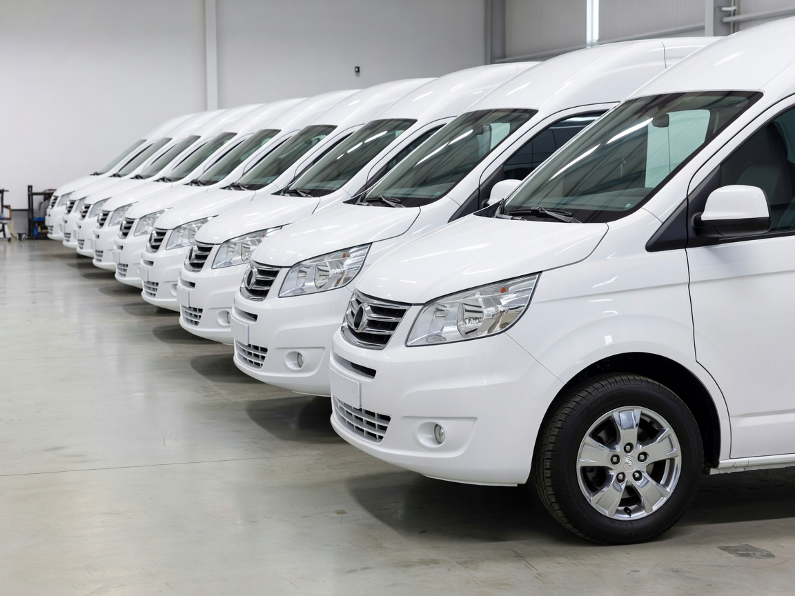 Row of clean business transport vans lined up, showing clear maintenance.